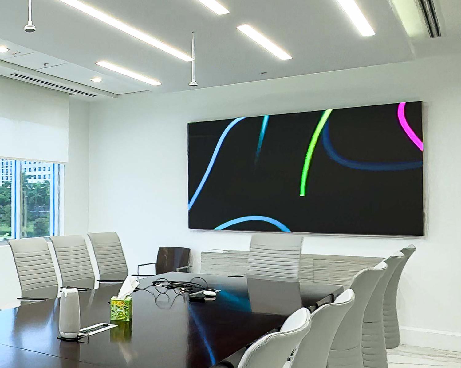 Bright executive meeting room with large MicroLED display on wall