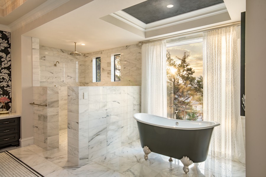 Lutron’s Ketra lighting softly illuminating a bathroom with a clawfoot tub and daylight streaming into the window.