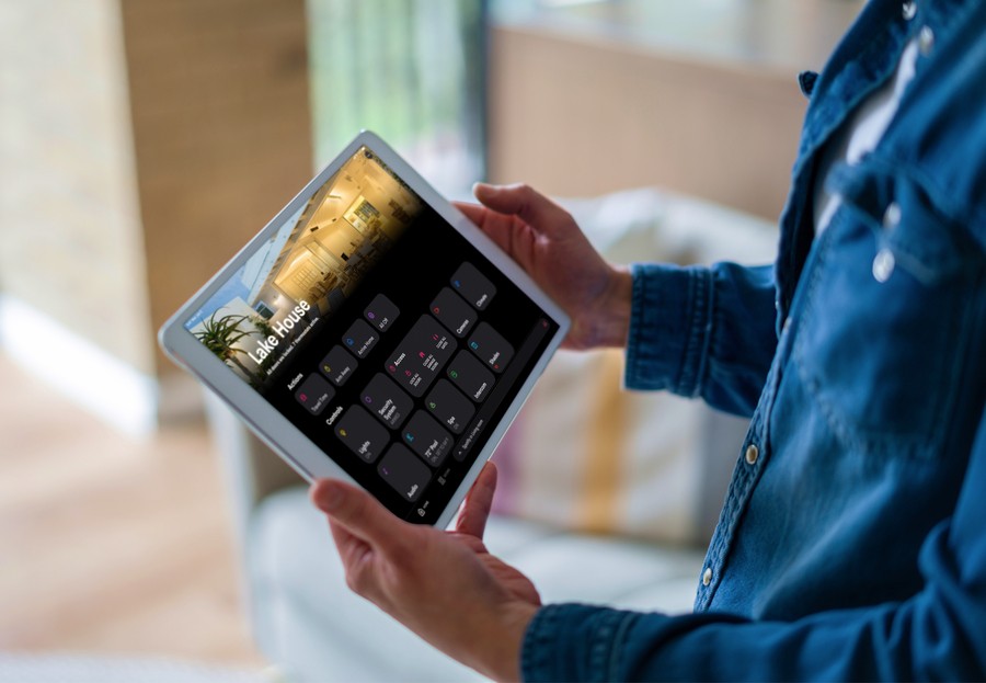 A person holding a Crestron home automation tablet.